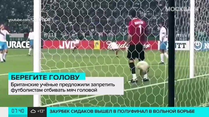 Футболист отбивает мяч головой.